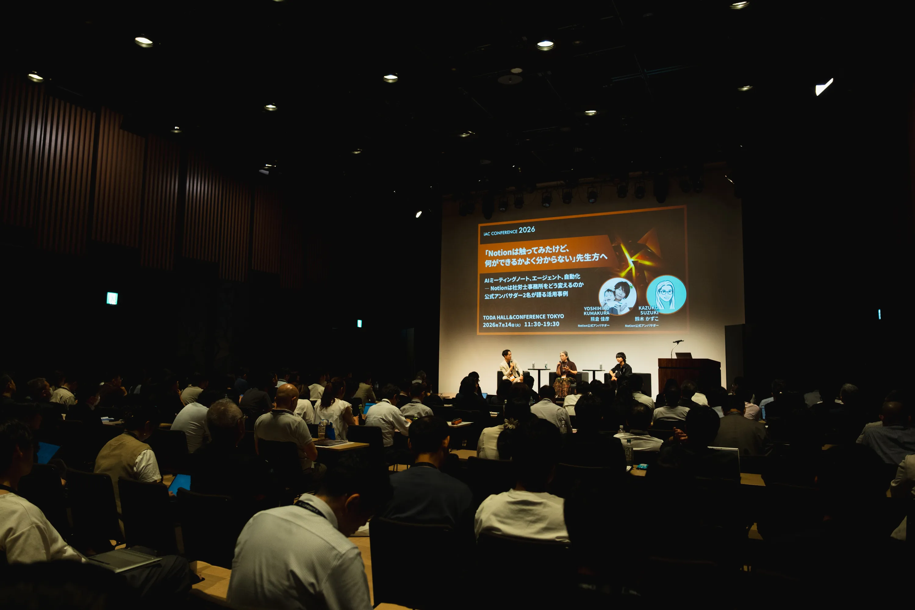 iAC CONFERENCE 2026の会場。満席の客席の前で登壇している様子